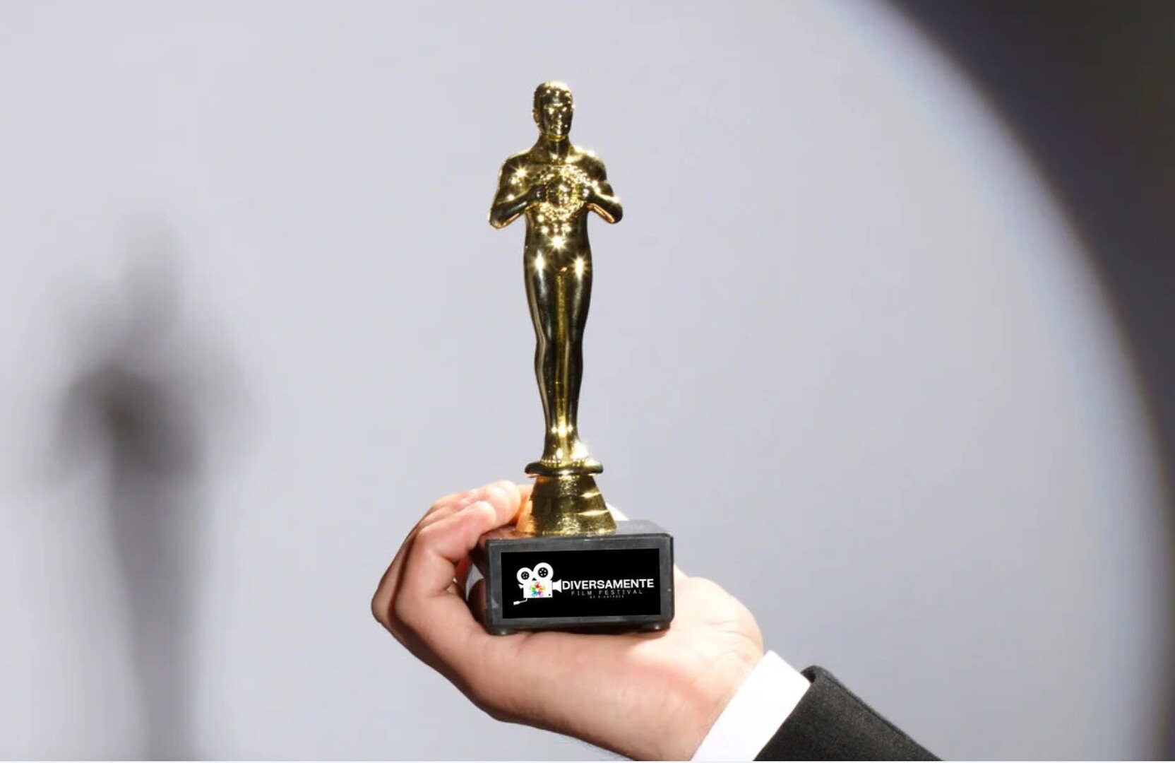 Statuetta dorata del Diversamente Film Festival di Viareggio tenuta in mano